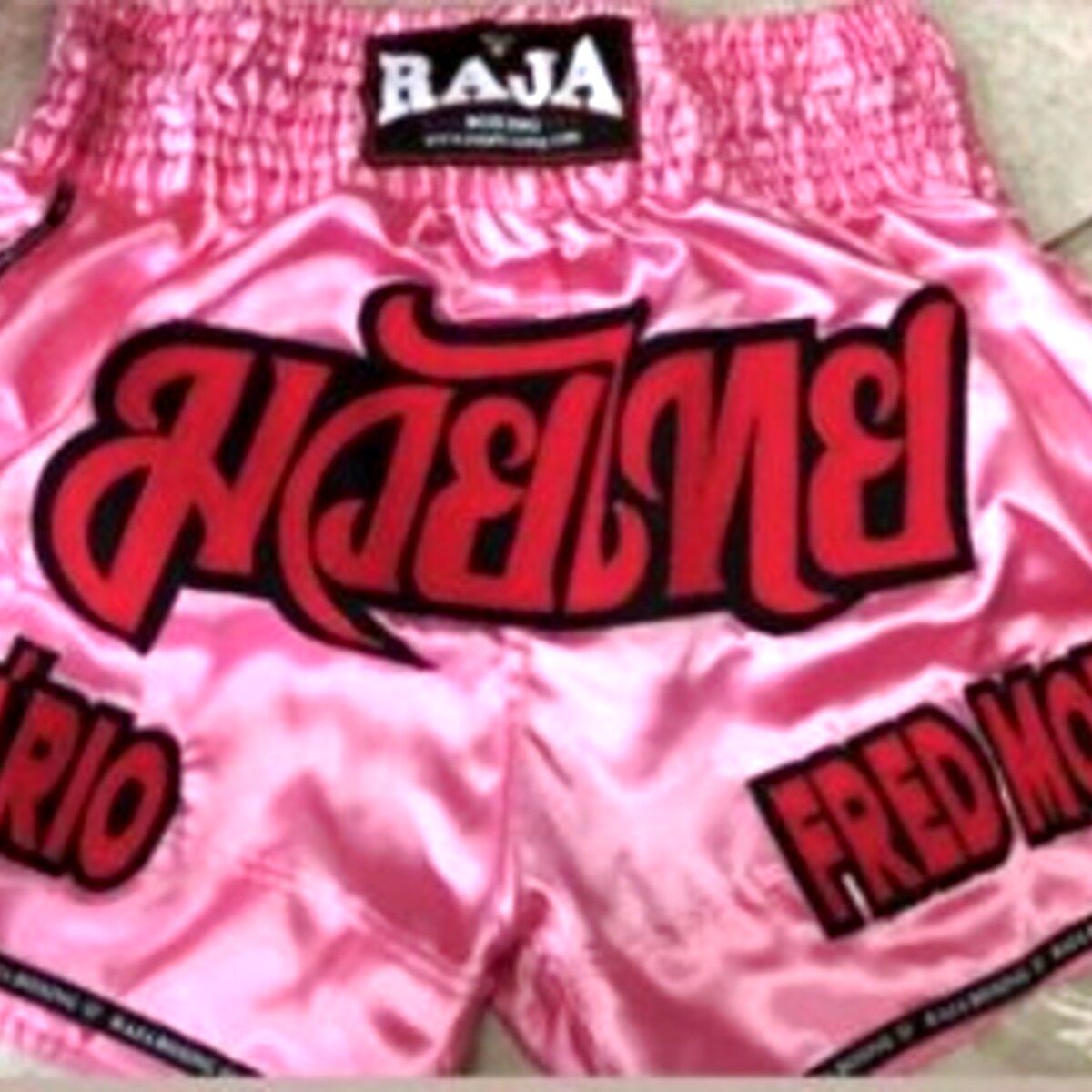 RAJA custom Muay Thai shorts — pink with fighter name 'Fred Motta'